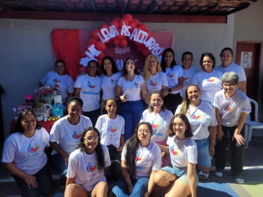 Equipe e voluntárias do CEPIS, de camiseta com o logotipo, reunidas em evento ao ar livre.